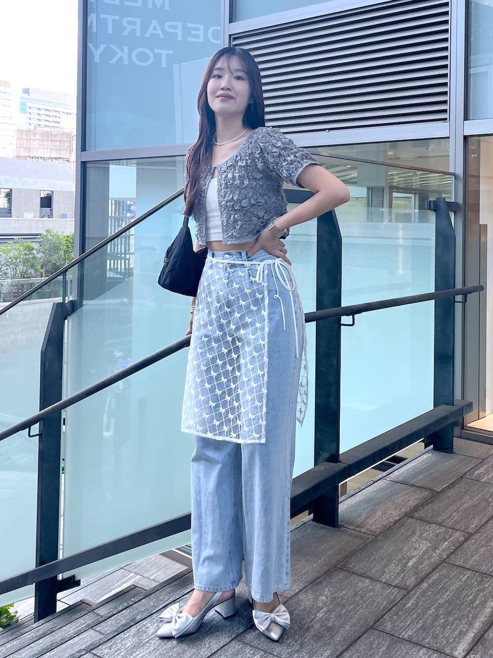 シルバー系のサンダル、ホワイト系のキャミソール、ブルー系のデニムパンツを着用したレディースの夏コーディネートの4枚目の写真