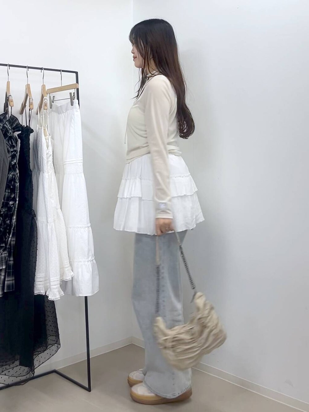 ホワイト系のキャミソール、ブルー系のデニムパンツ、ホワイト系のスカートを着用したレディースの春コーディネートの2枚目の写真