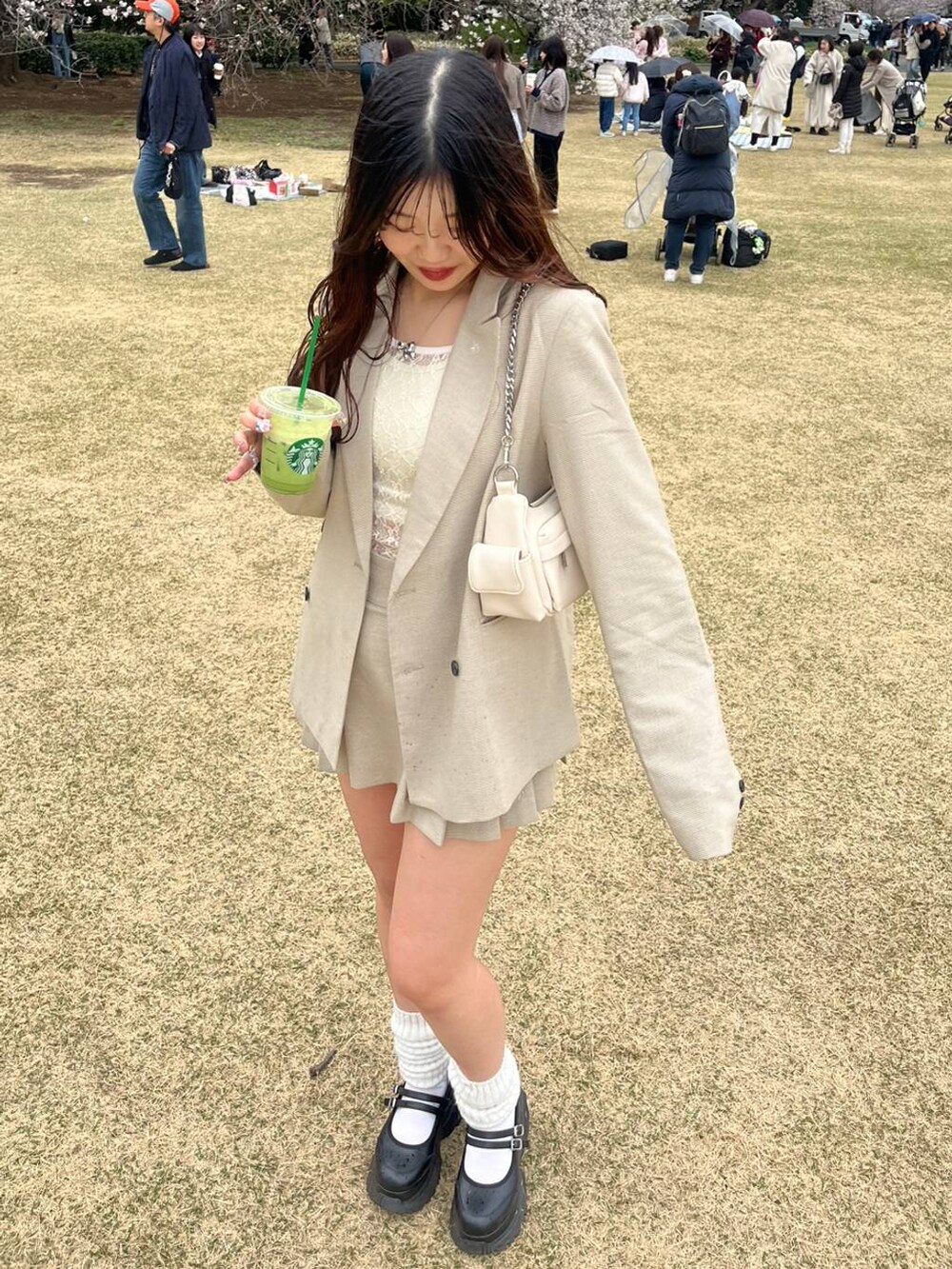 ホワイト系のキャミソール、ベージュ系のスカート、シルバー系のネックレスを着用したレディースの春コーディネートの2枚目の写真