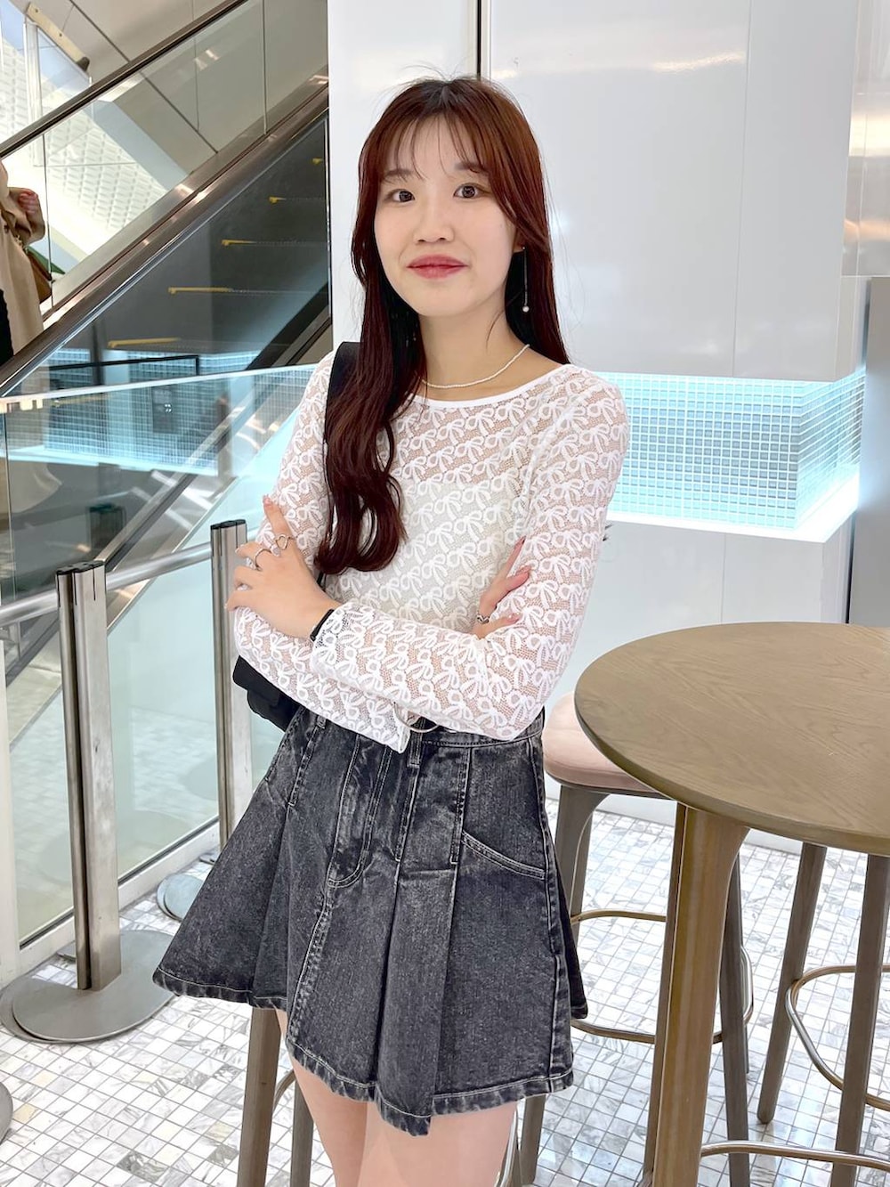 ブラック系のショルダーバッグ、ブラック系のローファー、ブラック系のデニムスカートを着用したレディースの春コーディネートの8枚目の写真