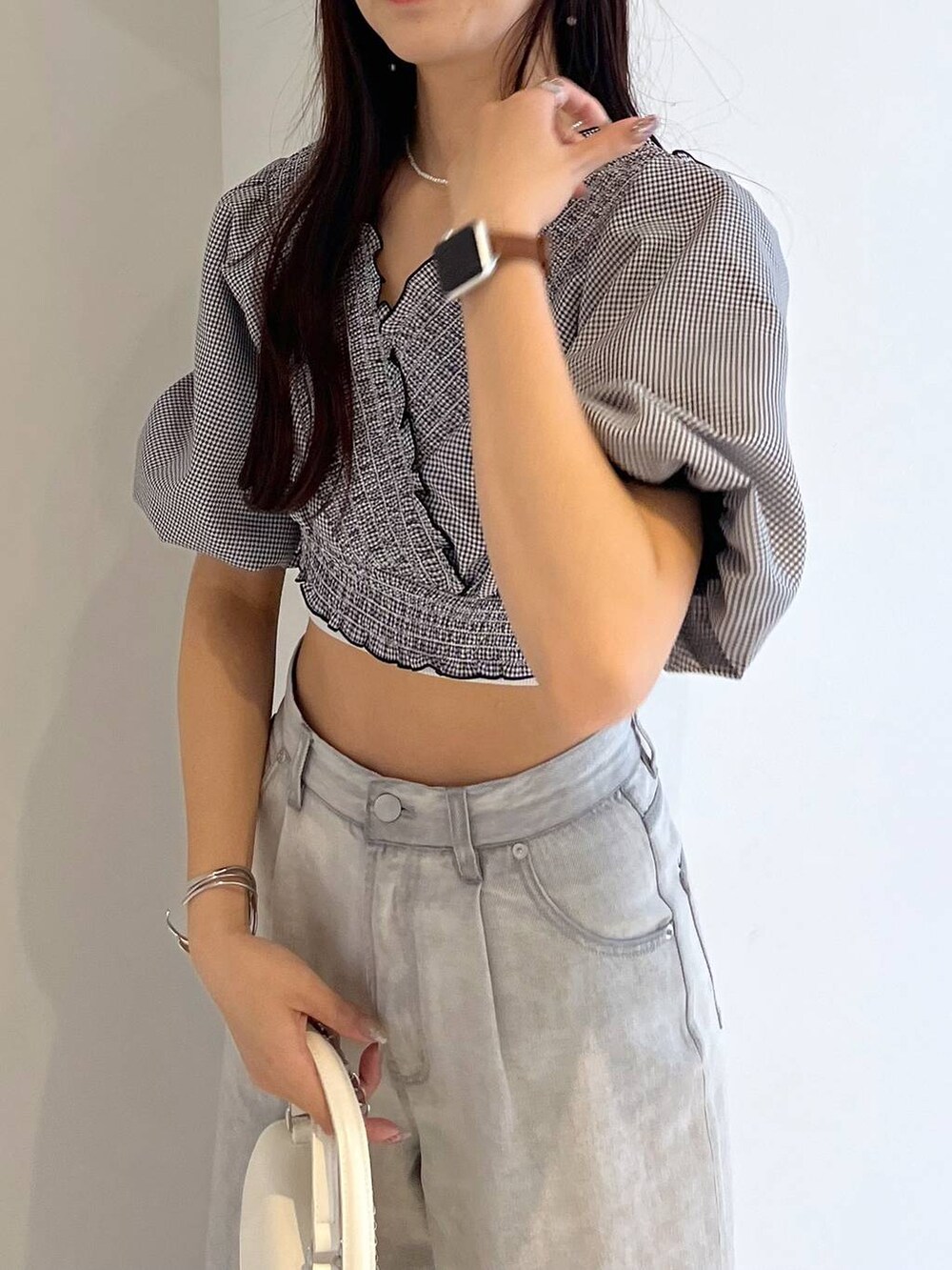 シルバー系のサンダル、ホワイト系のキャミソール、グレー系のデニムパンツを着用したレディースの夏コーディネートの6枚目の写真