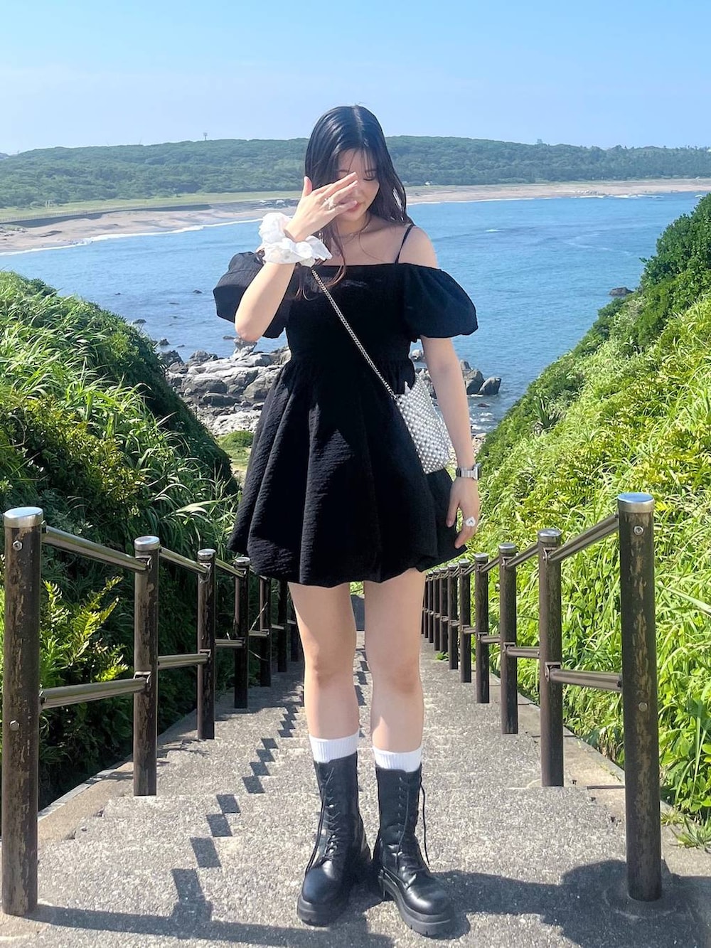 ホワイト系のキャミソール、ブラック系のワンピース、ブラック系のブーツを着用したレディースの夏コーディネートの4枚目の写真