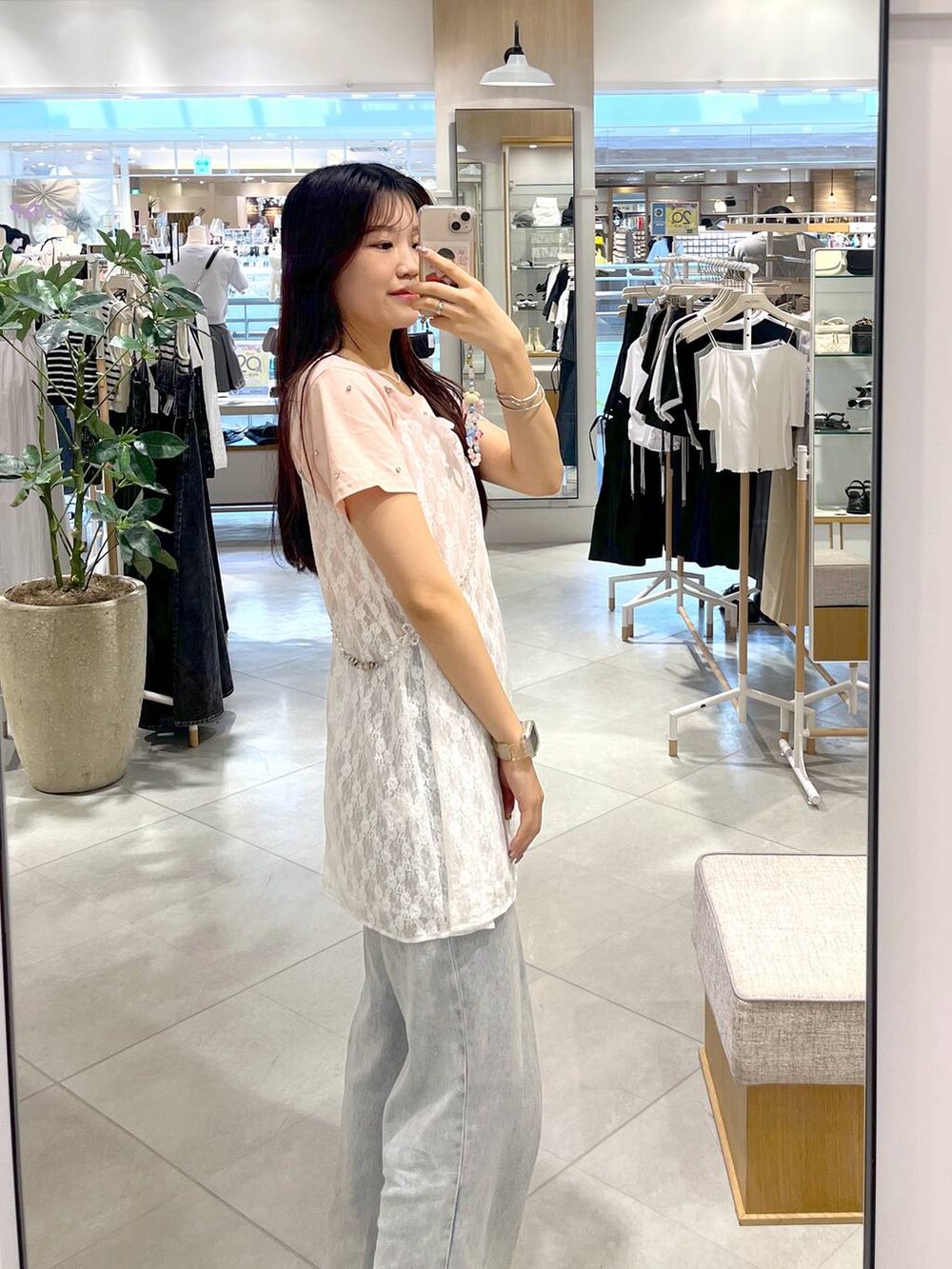 シルバー系のサンダル、ホワイト系のキャミソール、ブルー系のデニムパンツを着用したレディースの春コーディネートの4枚目の写真