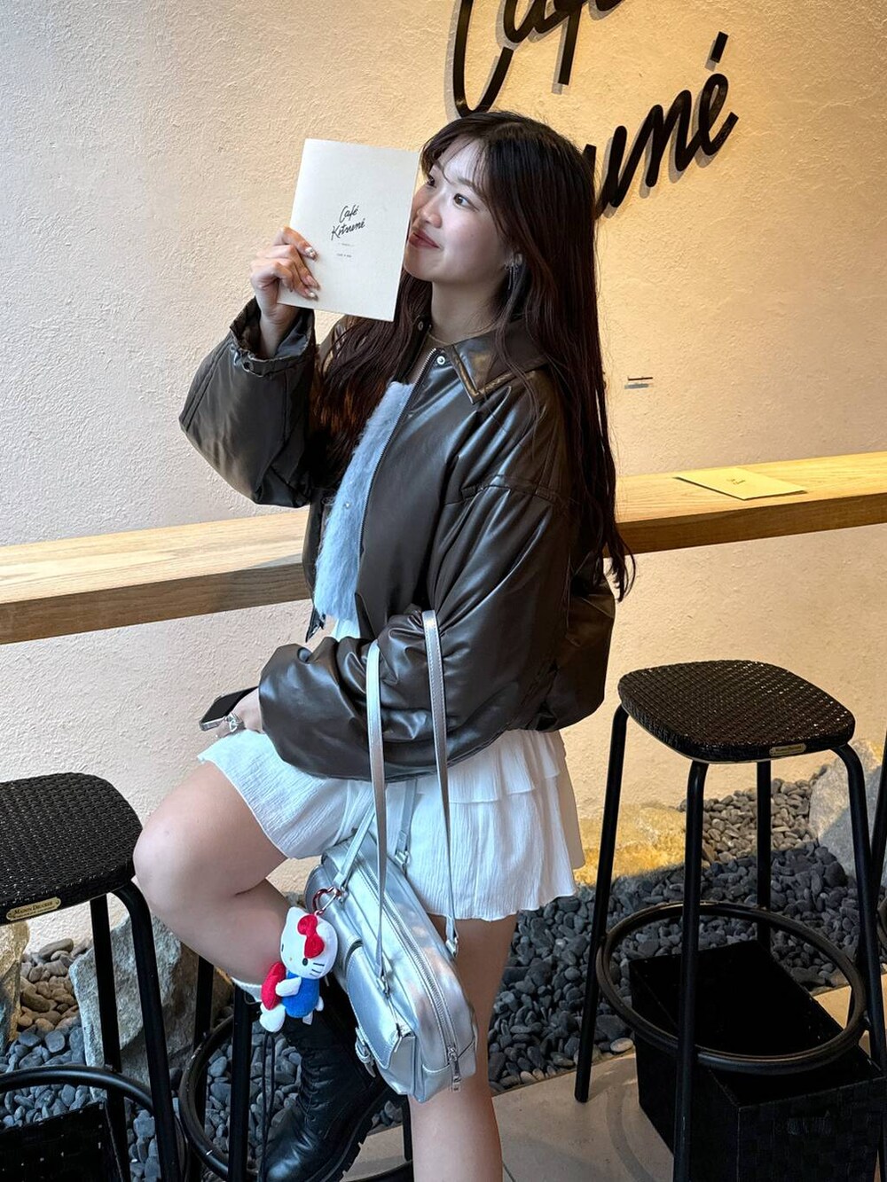 ホワイト系のTシャツ/カットソー、シルバー系のショルダーバッグ、ブルー系のニット/セーターを着用したレディースの冬コーディネートの4枚目の写真