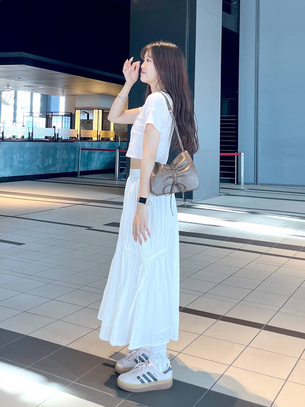 ピンク系のTシャツ/カットソー、ブラウン系のショルダーバッグ、ホワイト系のキャミソールを着用したレディースの春コーディネートの2枚目の写真