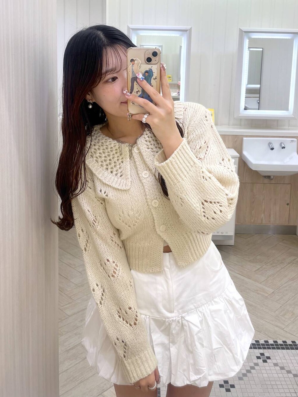 ホワイト系のキャミソール、ホワイト系のスカート、ホワイト系のカーディガン/ボレロを着用したレディースの冬コーディネートの6枚目の写真