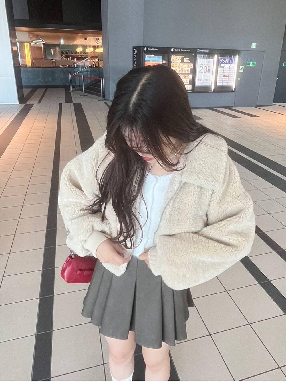 ホワイト系のTシャツ/カットソー、ホワイト系のカーディガン/ボレロ、ベージュ系のブーツを着用したレディースの冬コーディネートの4枚目の写真