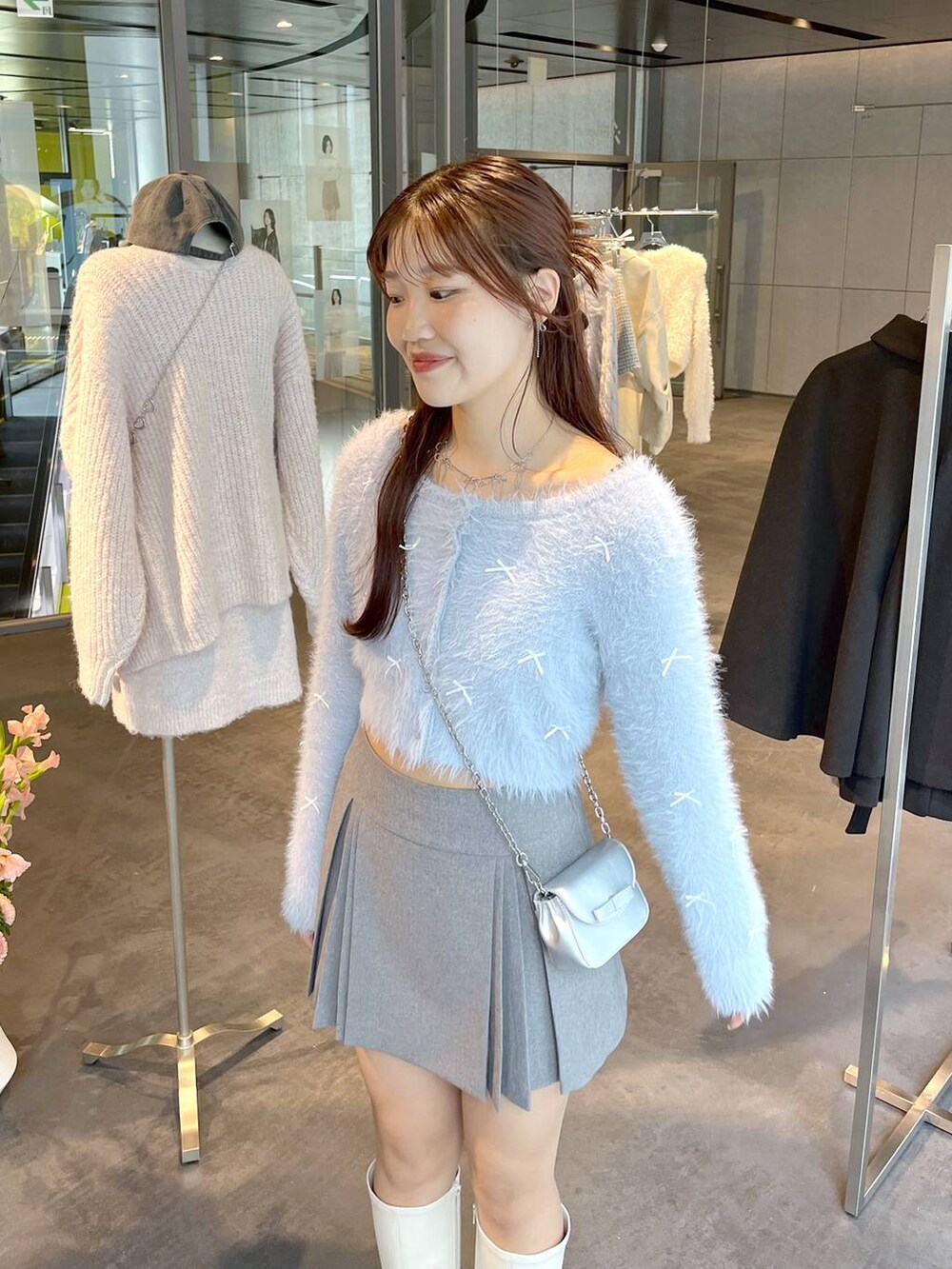 グレー系のスカート、ホワイト系のブーツ、ホワイト系のTシャツ/カットソーを着用したレディースの秋コーディネートの8枚目の写真