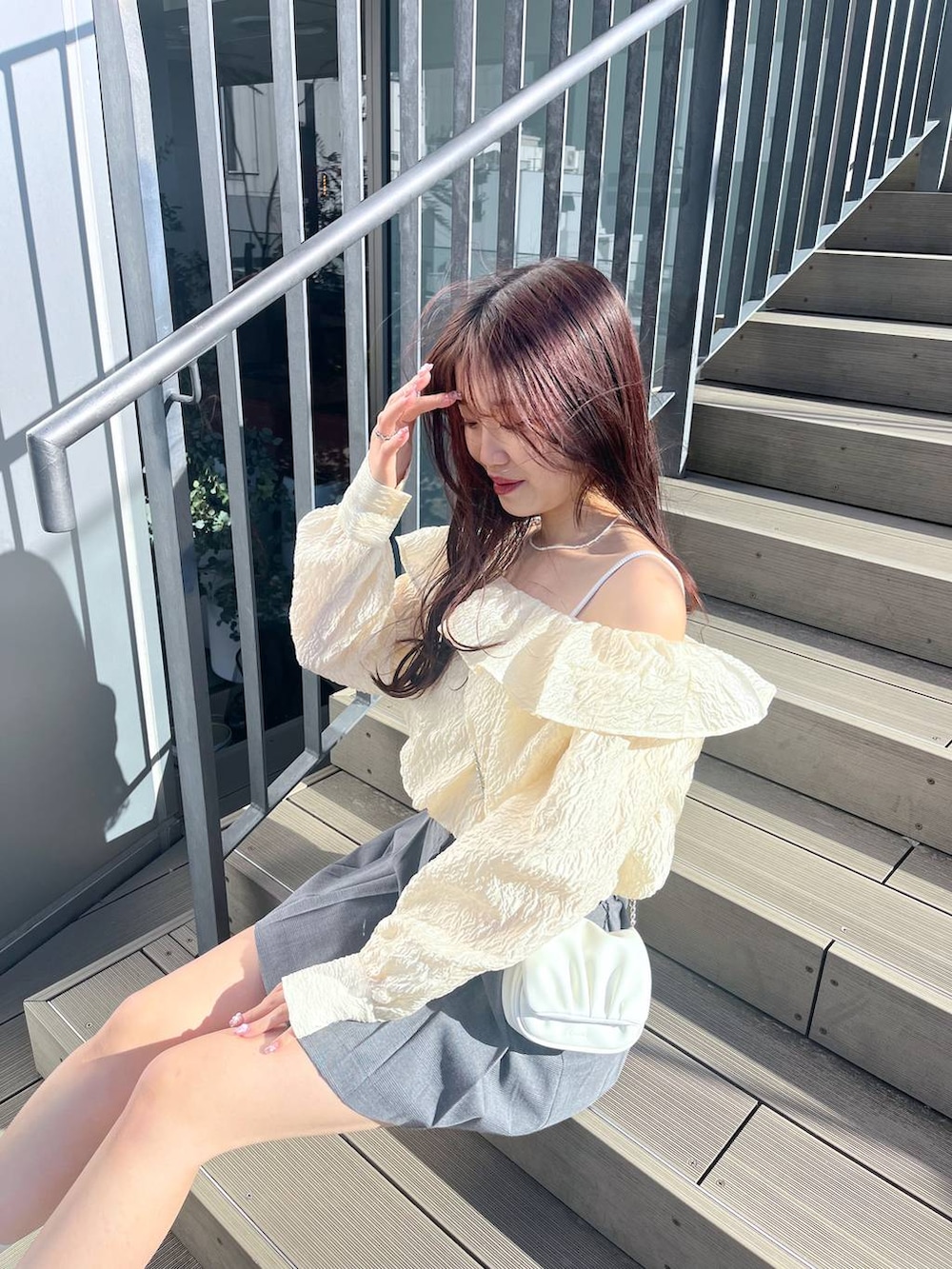 ホワイト系のショルダーバッグ、ホワイト系のキャミソール、ホワイト系のサンダルを着用したレディースの春コーディネートの3枚目の写真