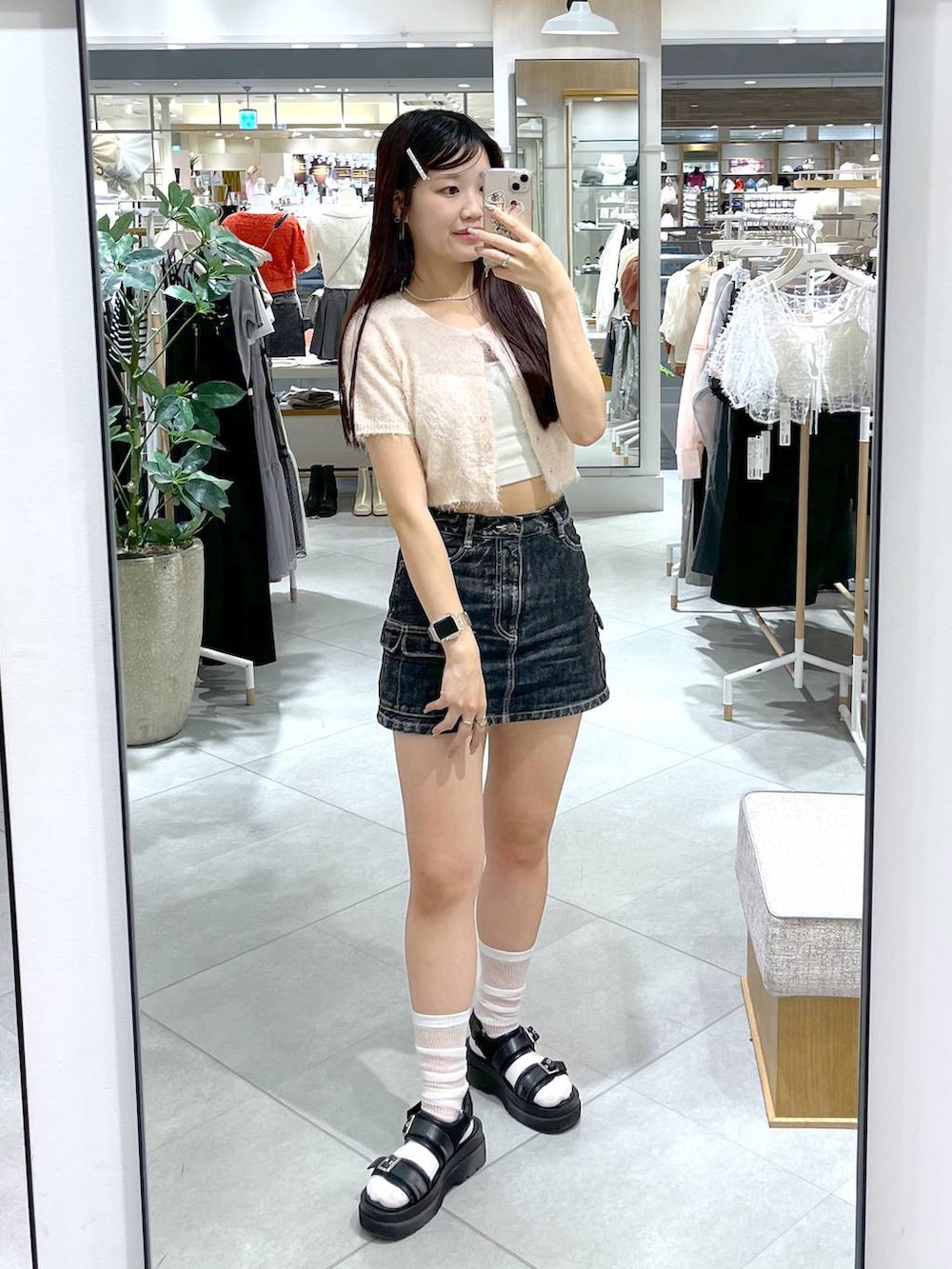 ピンク系のカーディガン/ボレロ、ホワイト系のキャミソール、ブラック系のデニムスカートを着用したレディースの春コーディネートの3枚目の写真