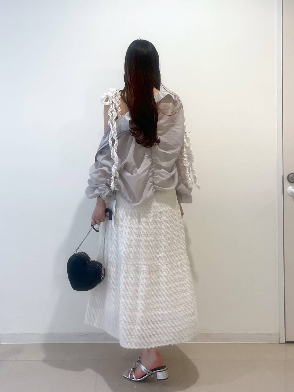 シルバー系のサンダル、ホワイト系のワンピース、グレー系のブルゾンを着用したレディースの春コーディネートの4枚目の写真