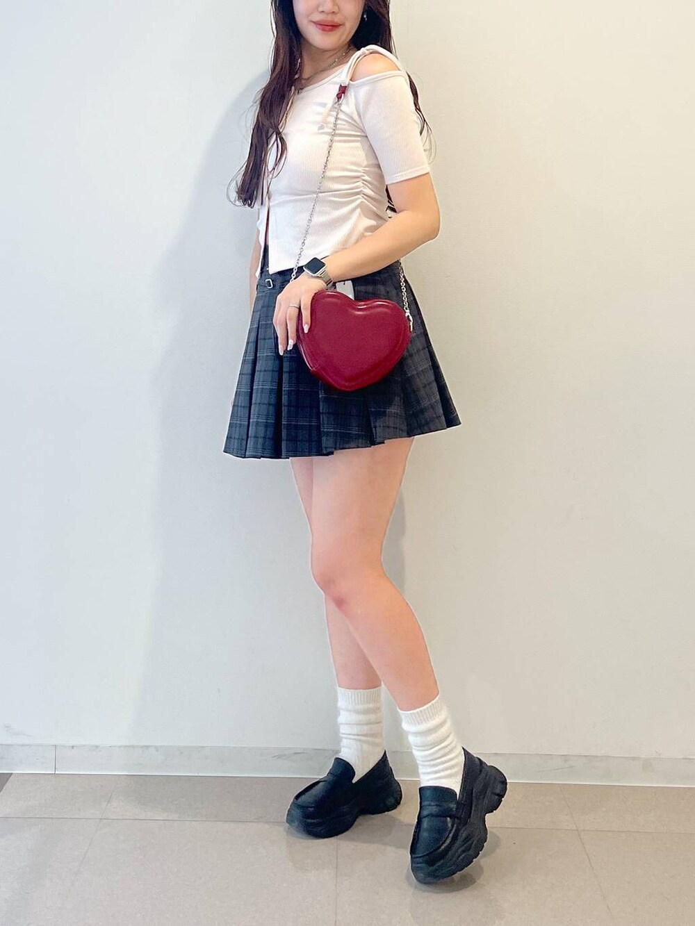 ブラック系のローファー、グレー系のスカート、レッド系のショルダーバッグを着用したレディースの春コーディネートの9枚目の写真