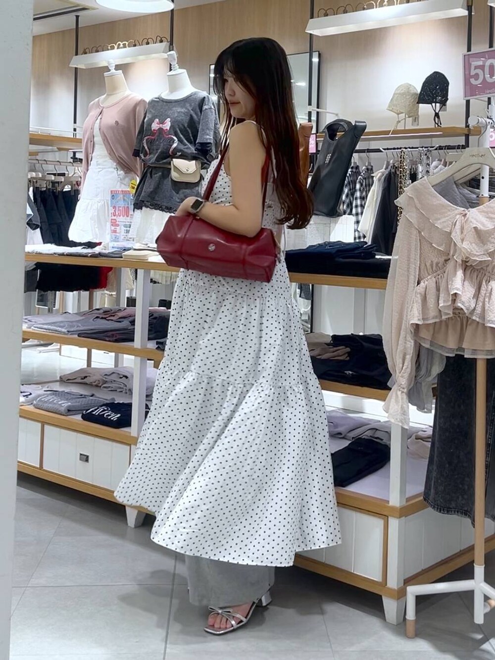 ホワイト系のキャミソール、シルバー系のサンダル、レッド系のボストンバッグを着用したレディースの春コーディネートの2枚目の写真