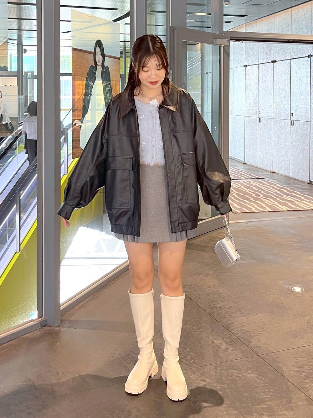 グレー系のスカート、ブルー系のカーディガン/ボレロ、ホワイト系のブーツを着用したレディースの秋コーディネートの3枚目の写真