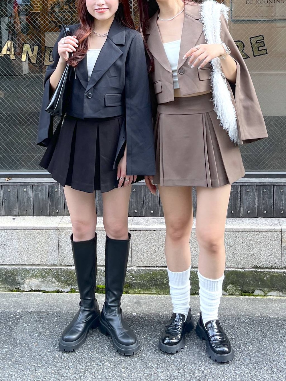 ブラック系のテーラードジャケット、ブラウン系のテーラードジャケット、ブラウン系のスカートを着用したレディースの冬コーディネートの6枚目の写真