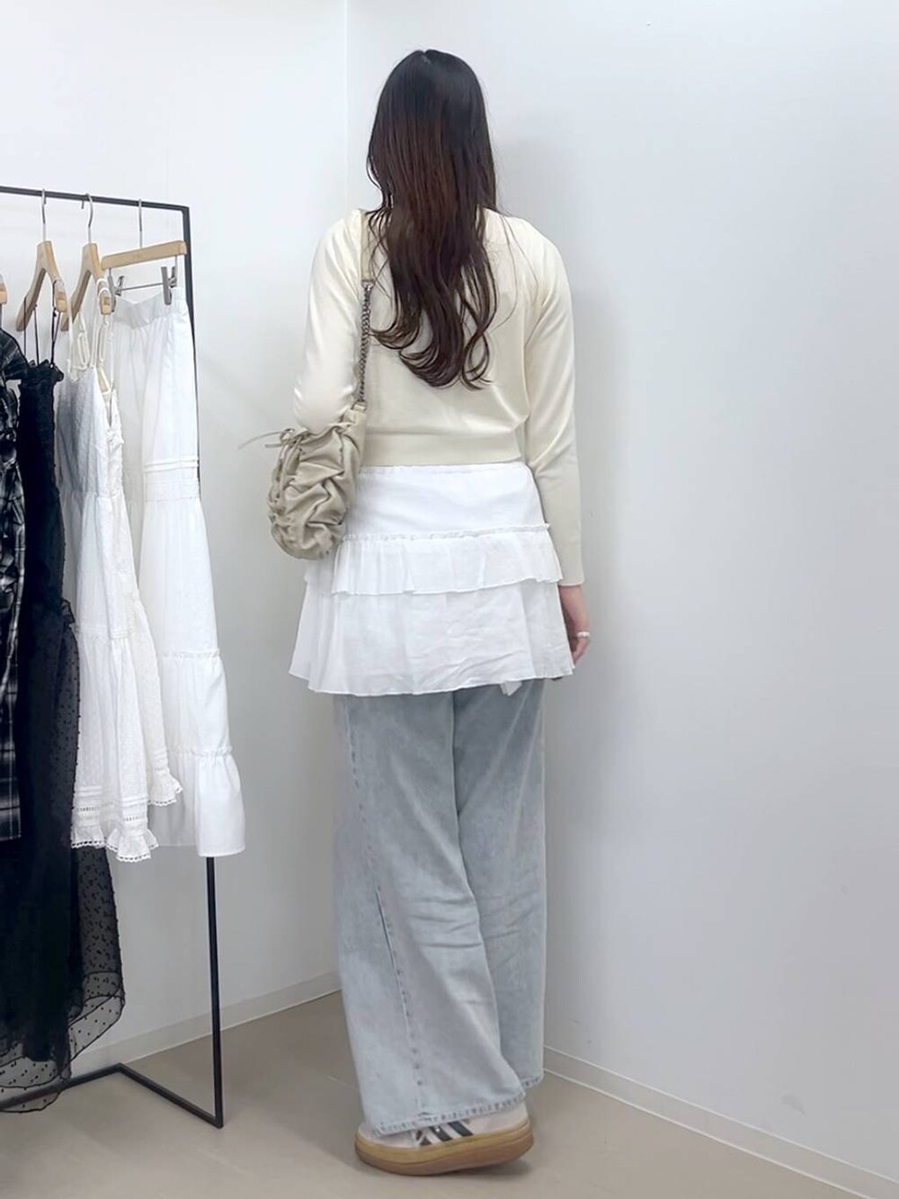 ホワイト系のキャミソール、ブルー系のデニムパンツ、ホワイト系のスカートを着用したレディースの春コーディネートの6枚目の写真