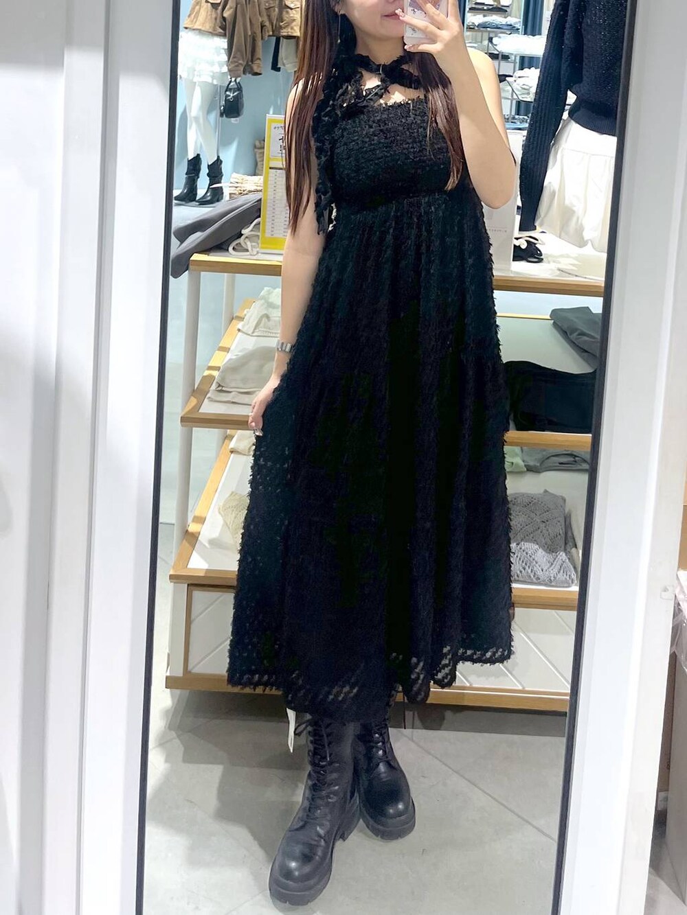 ホワイト系のキャミソール、ブラック系のワンピース、ブラック系のブーツを着用したレディースの春コーディネートの2枚目の写真