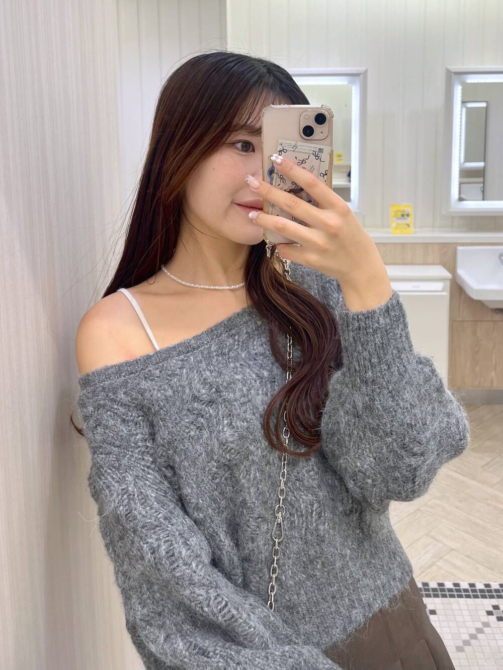 ブラウン系のスカート、ホワイト系のキャミソール、シルバー系のショルダーバッグを着用したレディースの秋コーディネートの4枚目の写真