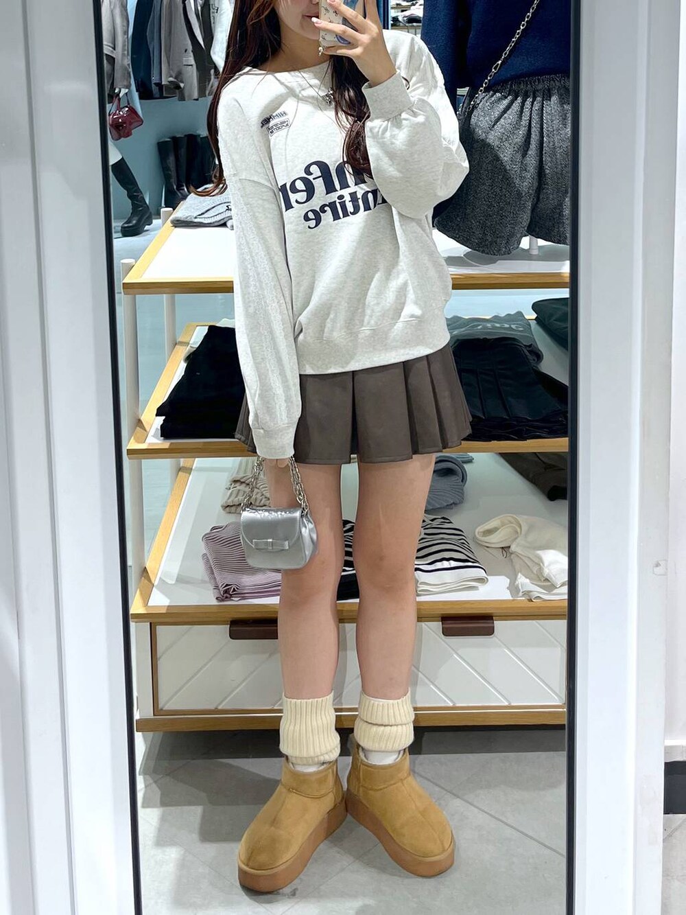 ホワイト系のTシャツ/カットソー、ブラウン系のスカート、ベージュ系のブーツを着用したレディースの秋コーディネートの6枚目の写真