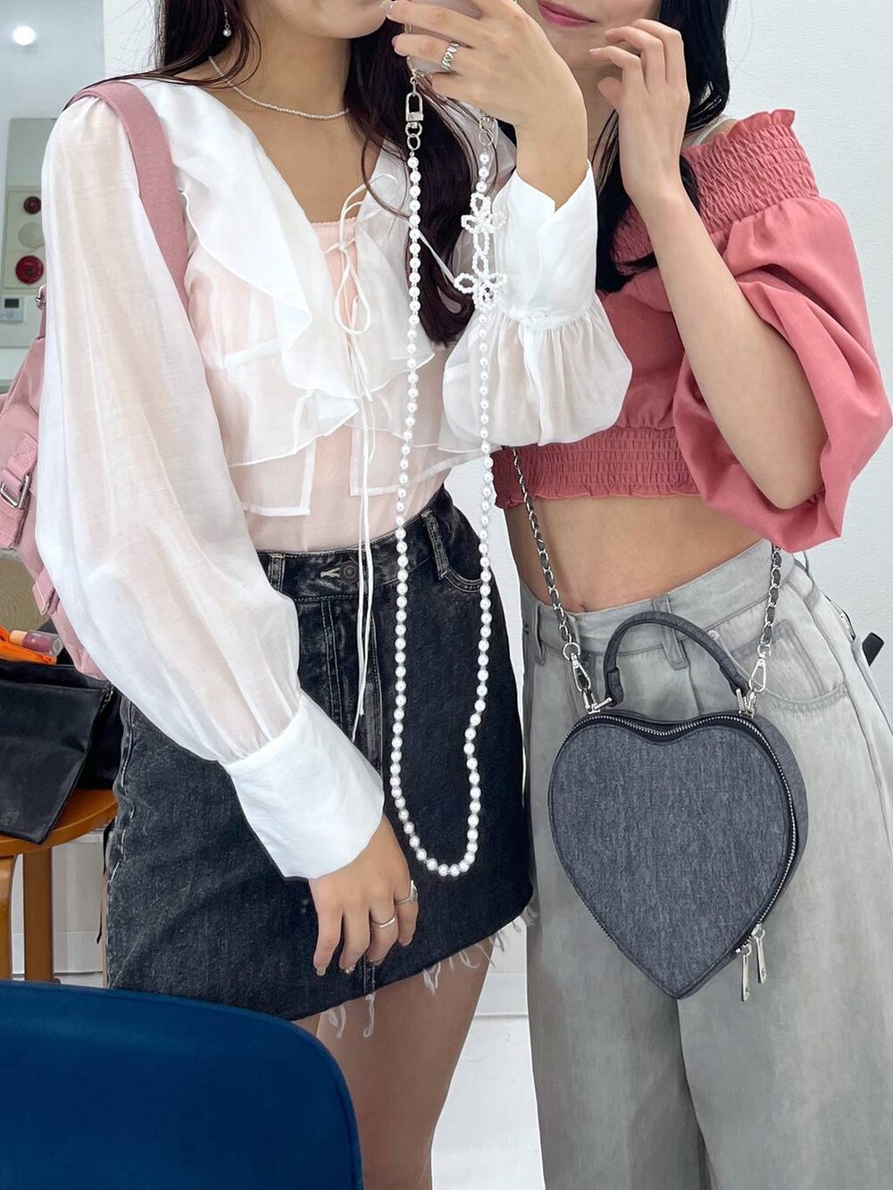 ピンク系のショルダーバッグ、ブラック系のショルダーバッグ、グレー系のデニムパンツを着用したレディースの春コーディネートの2枚目の写真