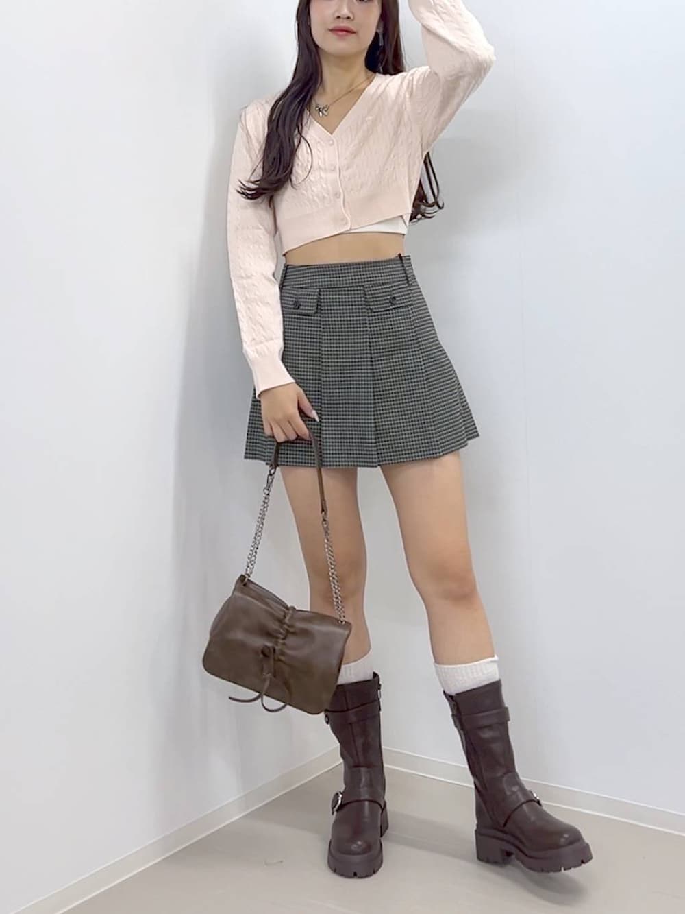 ブラウン系のショルダーバッグ、ブラウン系のブーツ、ホワイト系のキャミソールを着用したレディースの秋コーディネートの7枚目の写真