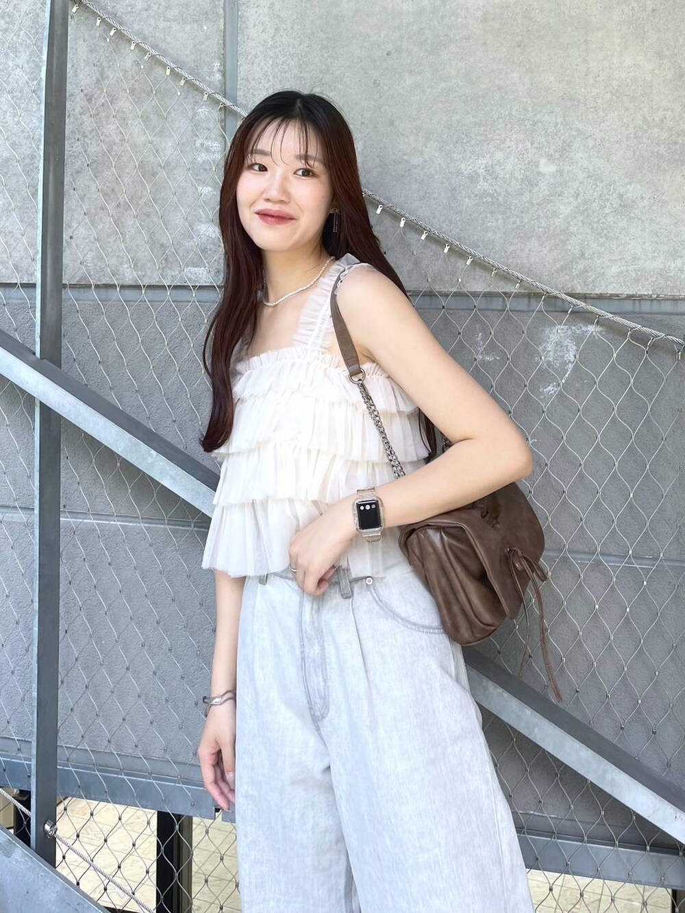 ブラウン系のショルダーバッグ、ホワイト系のキャミソール、ホワイト系のキャミソールを着用したレディースの夏コーディネートの4枚目の写真