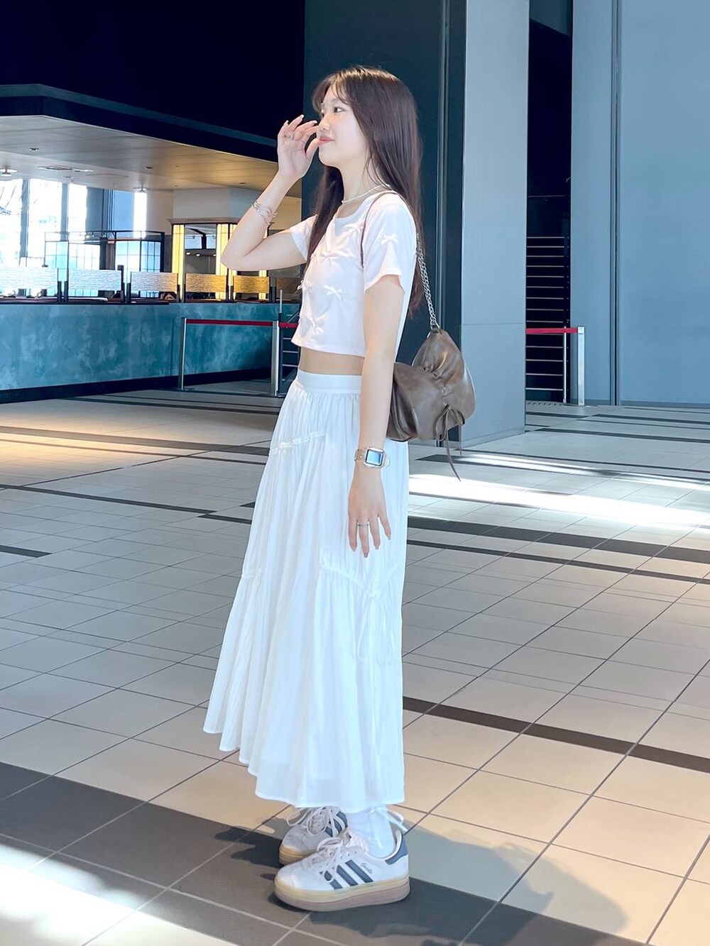 ピンク系のTシャツ/カットソー、ブラウン系のショルダーバッグ、ホワイト系のキャミソールを着用したレディースの春コーディネートの8枚目の写真