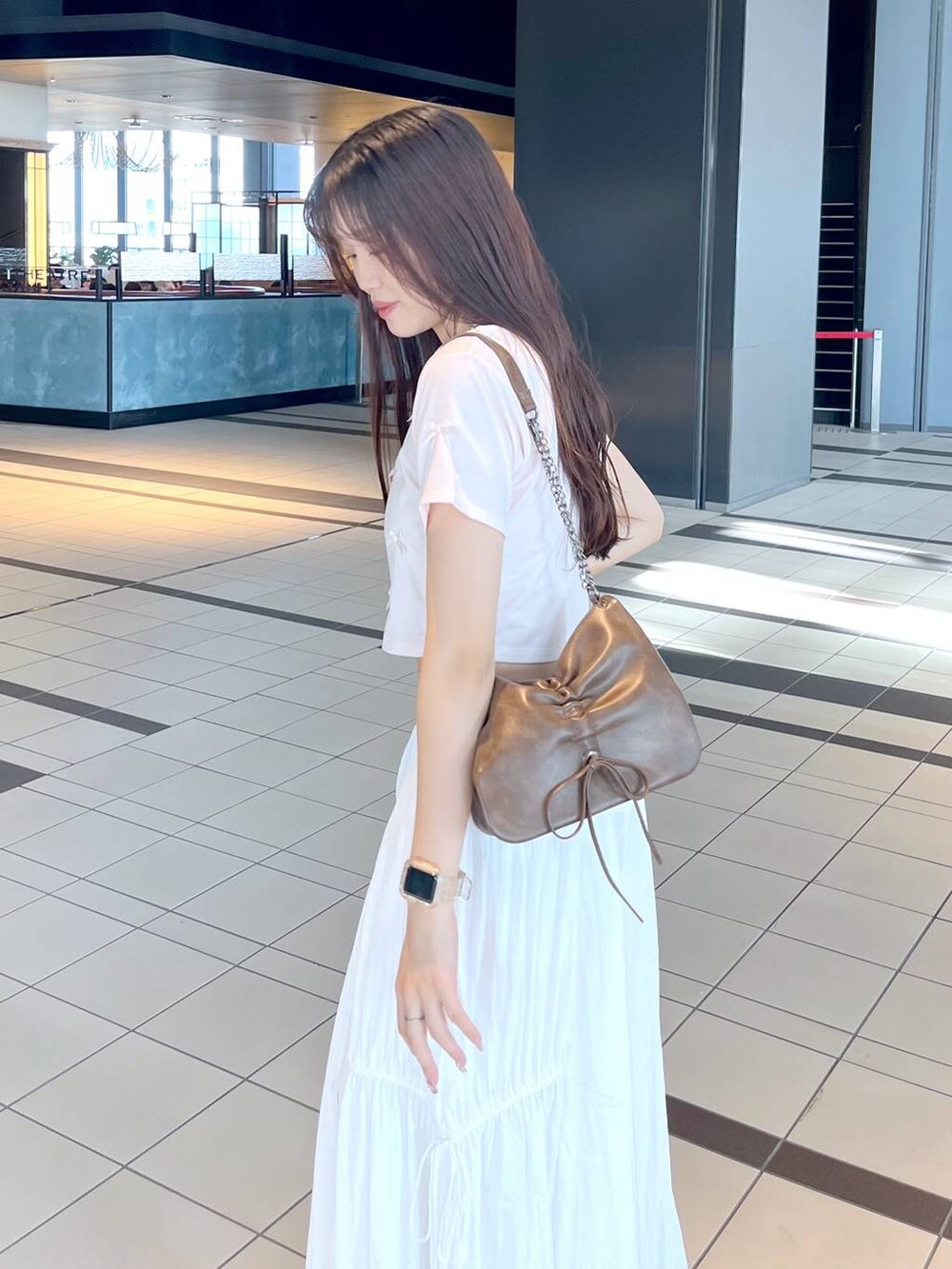 ピンク系のTシャツ/カットソー、ホワイト系のキャミソール、ブラウン系のショルダーバッグを着用したレディースの夏コーディネートの3枚目の写真