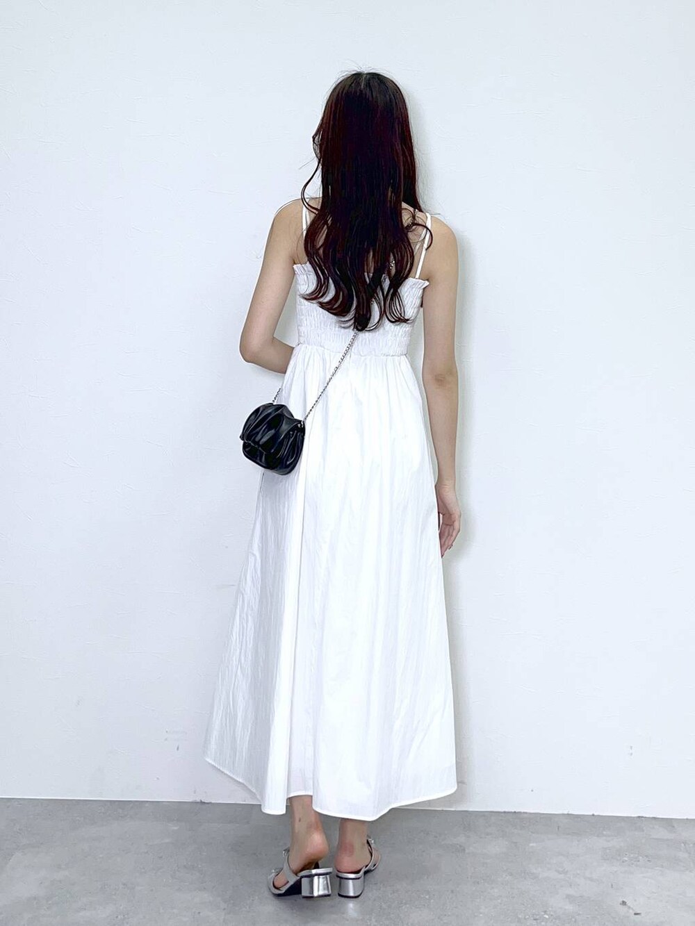 ブラック系のショルダーバッグ、シルバー系のサンダル、ホワイト系のワンピースを着用したレディースの夏コーディネートの3枚目の写真