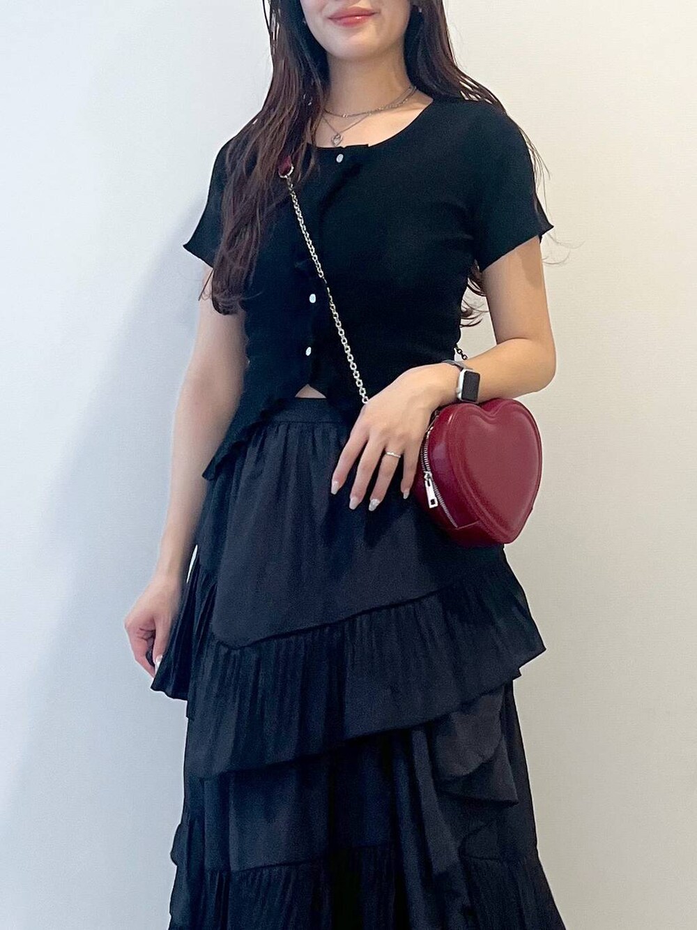 ホワイト系のキャミソール、ブラック系のスカート、シルバー系のサンダルを着用したレディースの春コーディネートの7枚目の写真