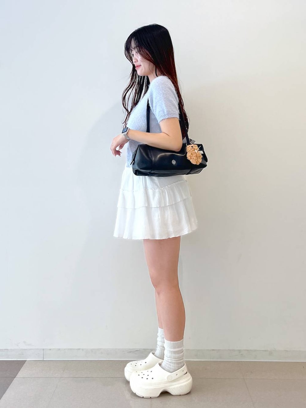 ホワイト系のスカート、ブラック系のボストンバッグ、ホワイト系のキャミソールを着用したレディースの春コーディネートの5枚目の写真
