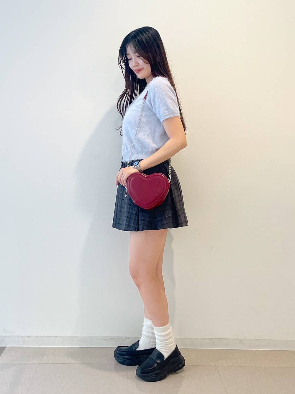 ブラック系のローファー、グレー系のスカート、レッド系のショルダーバッグを着用したレディースの春コーディネートの5枚目の写真