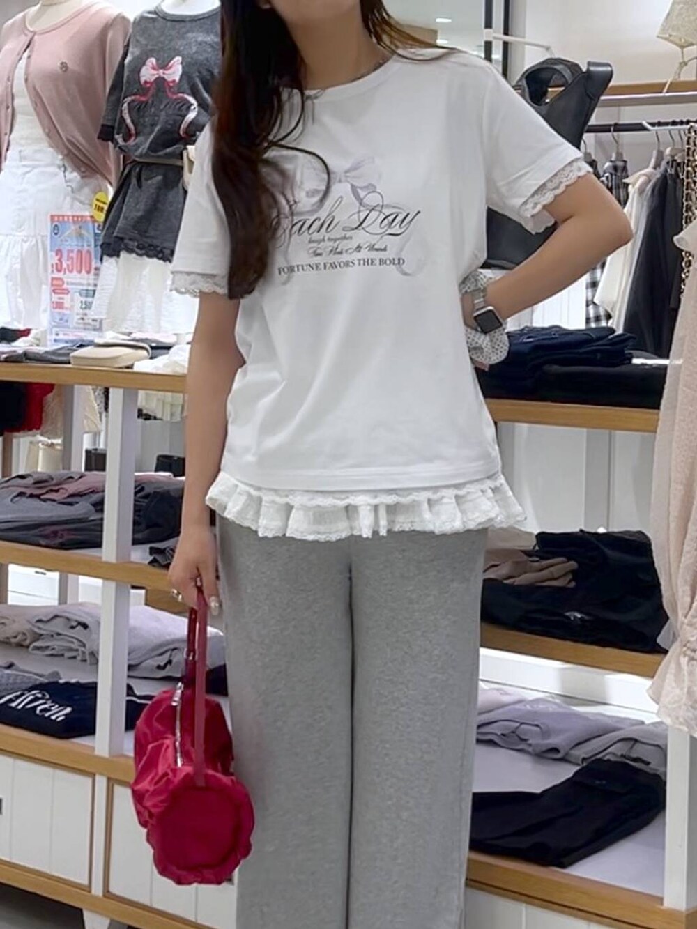 ホワイト系のキャミソール、レッド系のショルダーバッグ、グレー系のスウェットパンツを着用したレディースの春コーディネートの6枚目の写真