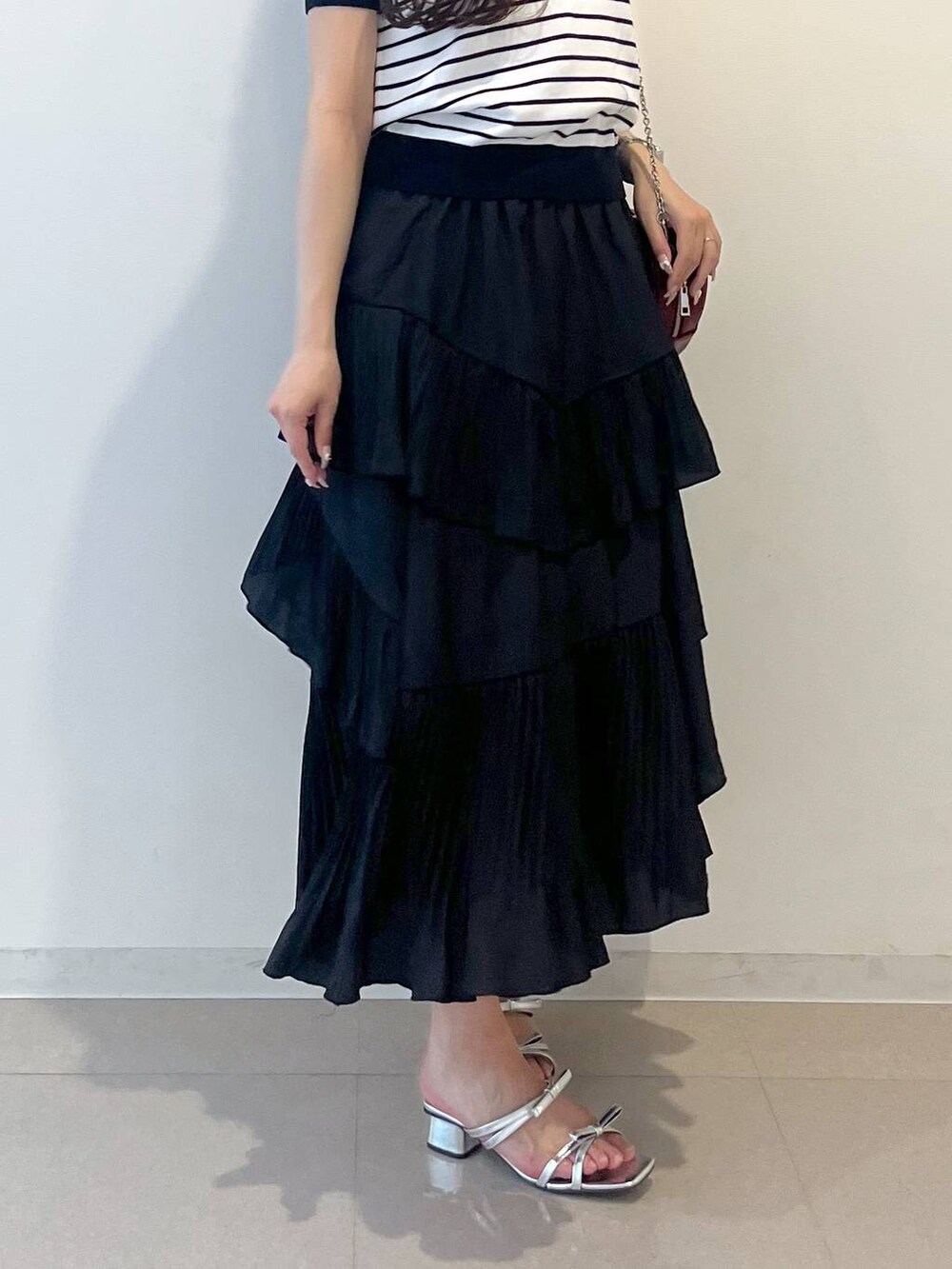 ホワイト系のキャミソール、ブラック系のスカート、シルバー系のサンダルを着用したレディースの春コーディネートの8枚目の写真