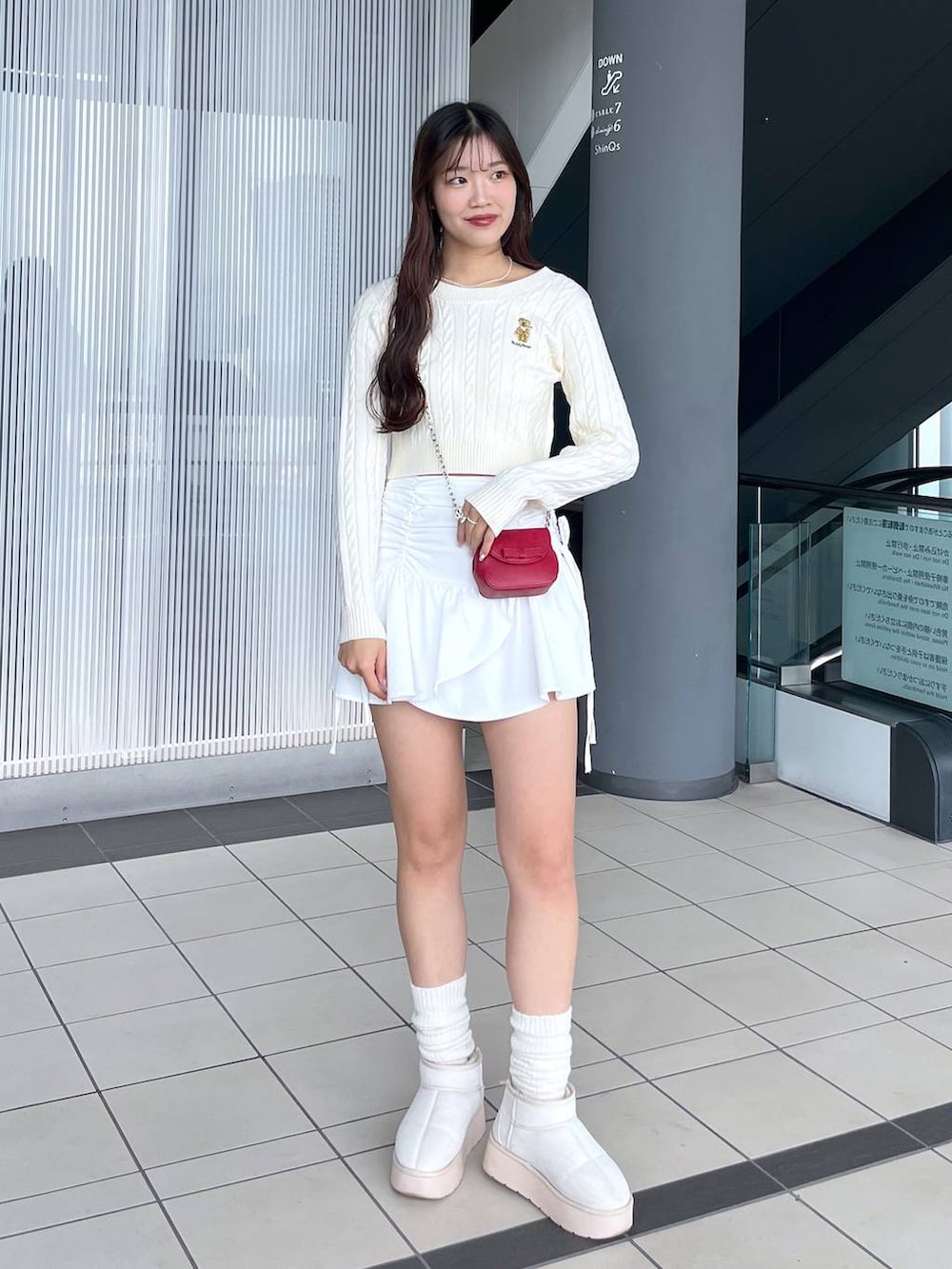 ホワイト系のTシャツ/カットソー、レッド系のショルダーバッグ、ホワイト系のブーツを着用したレディースの冬コーディネートの4枚目の写真