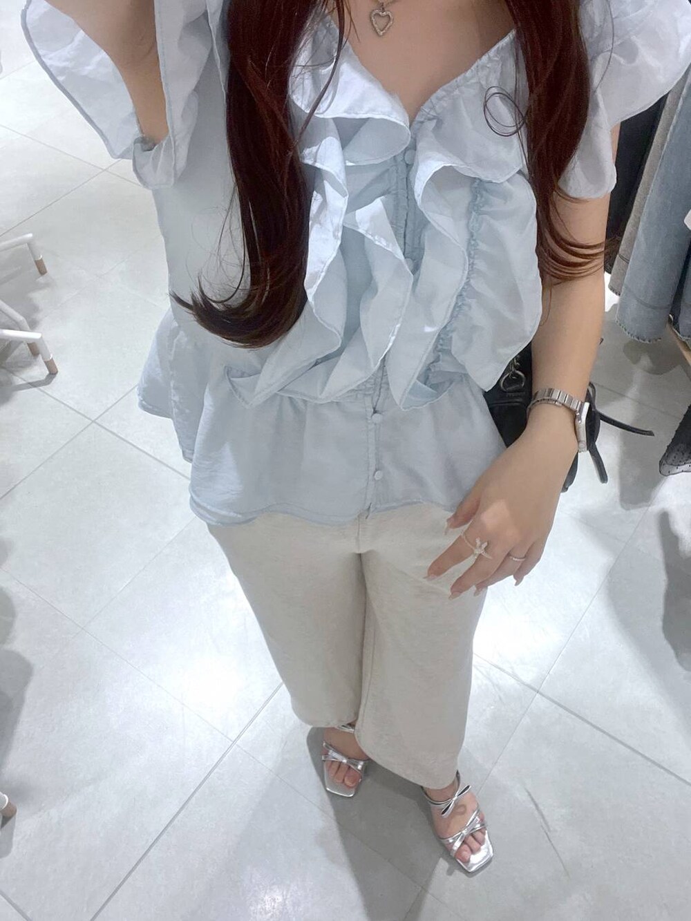 グレー系のショルダーバッグ、ホワイト系のキャミソール、シルバー系のサンダルを着用したレディースの春コーディネートの3枚目の写真