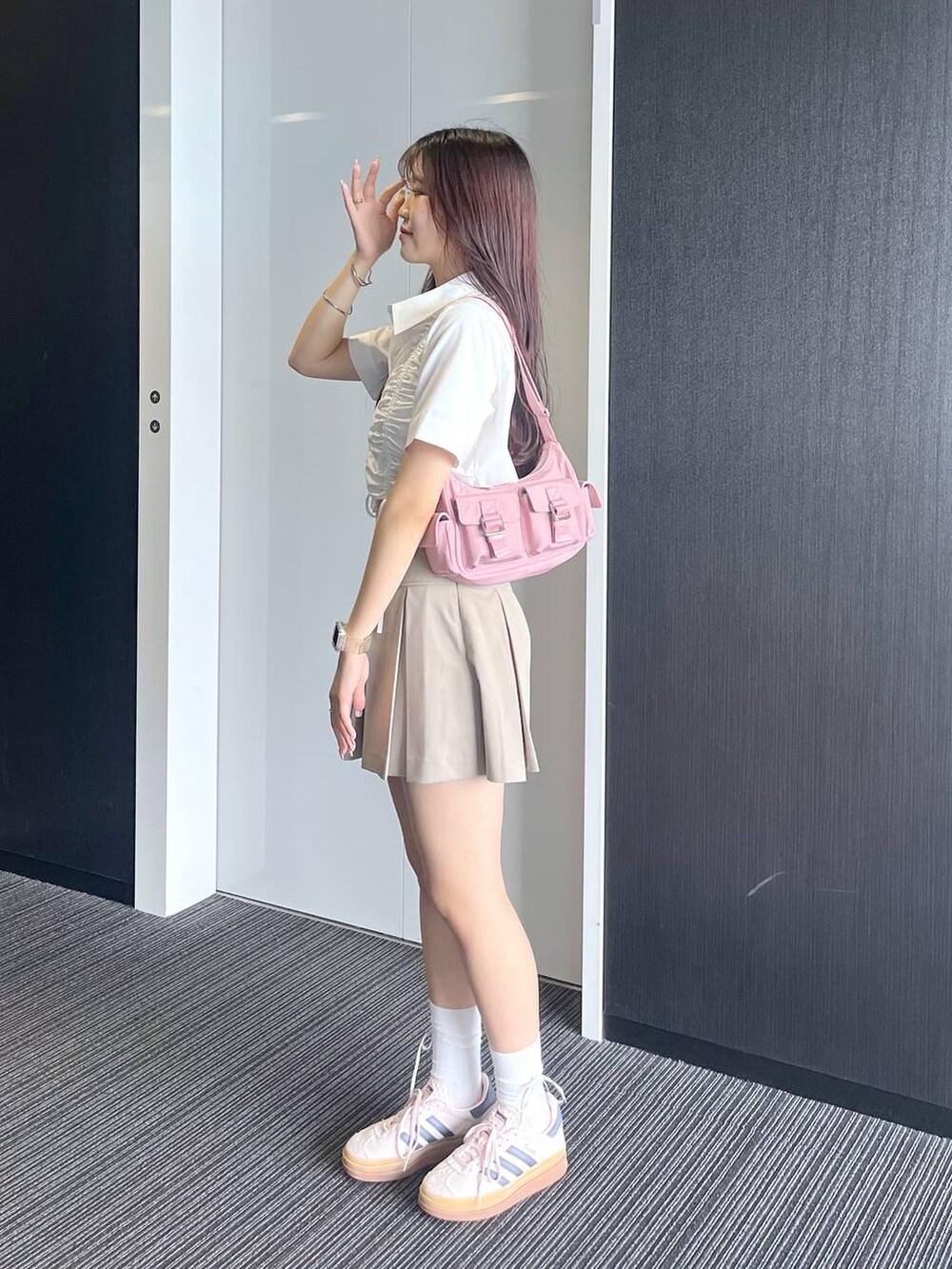 ピンク系のショルダーバッグ、ホワイト系のキャミソール、ベージュ系のスカートを着用したレディースの夏コーディネートの3枚目の写真