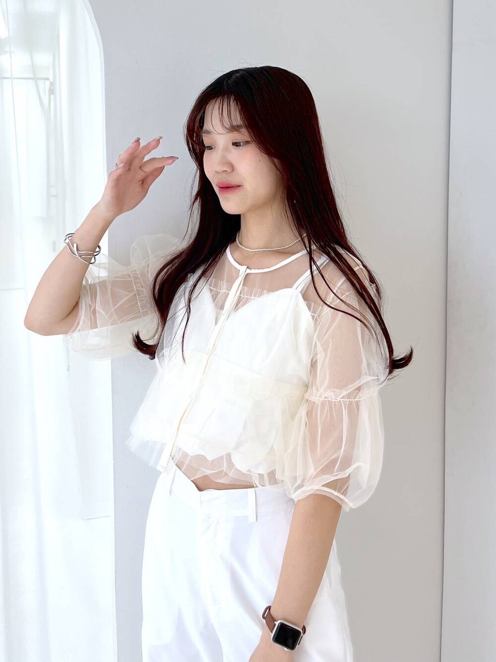 シルバー系のショルダーバッグ、ホワイト系のキャミソール、ホワイト系のベストを着用したレディースの夏コーディネートの4枚目の写真