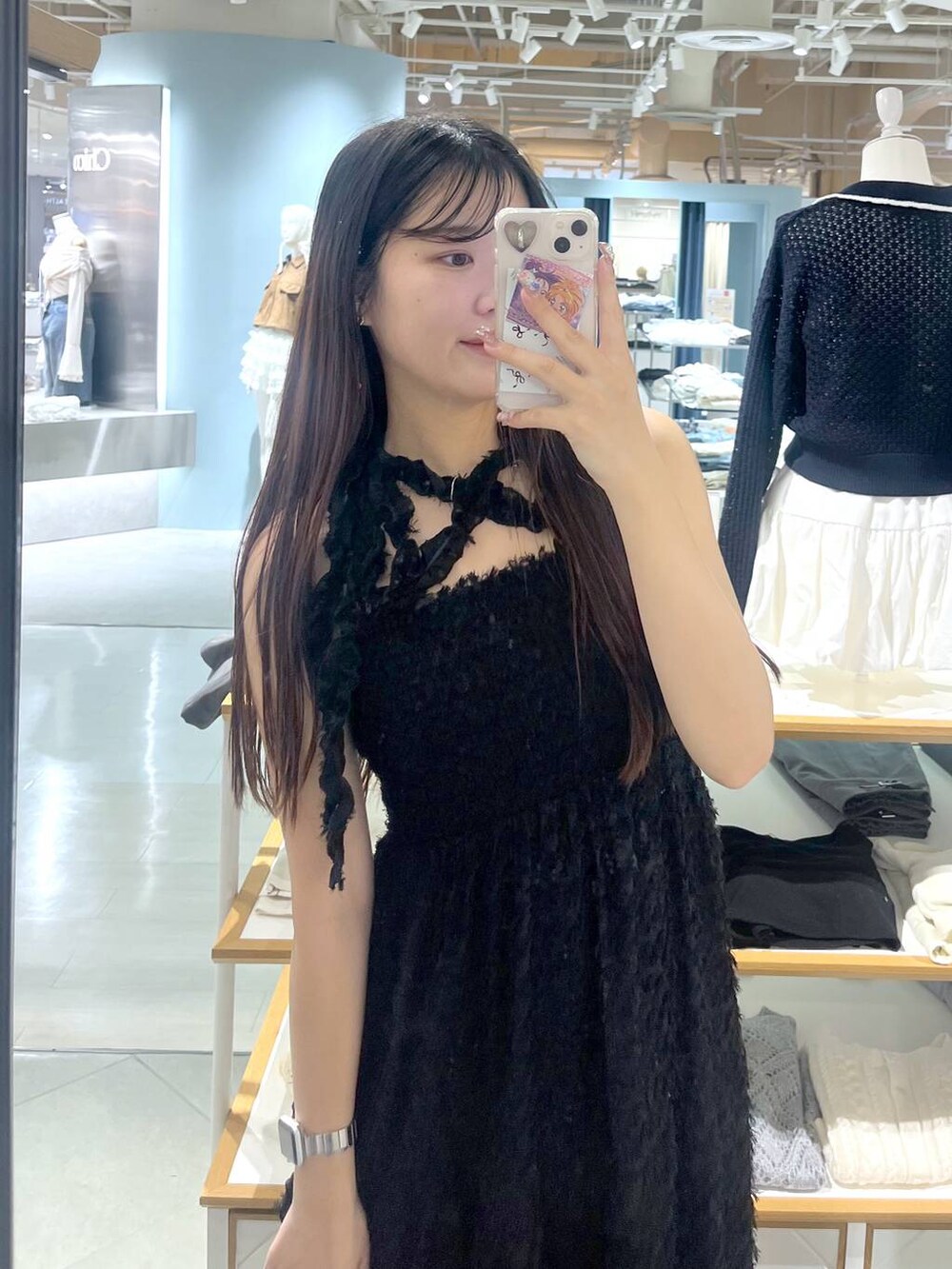 ホワイト系のキャミソール、ブラック系のワンピース、ブラック系のブーツを着用したレディースの春コーディネートの3枚目の写真