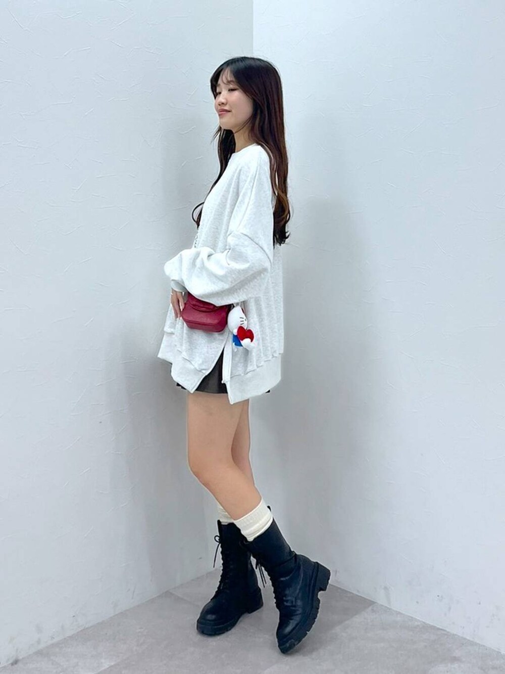 ホワイト系のTシャツ/カットソー、ブラウン系のスカート、レッド系のショルダーバッグを着用したレディースの秋コーディネートの7枚目の写真