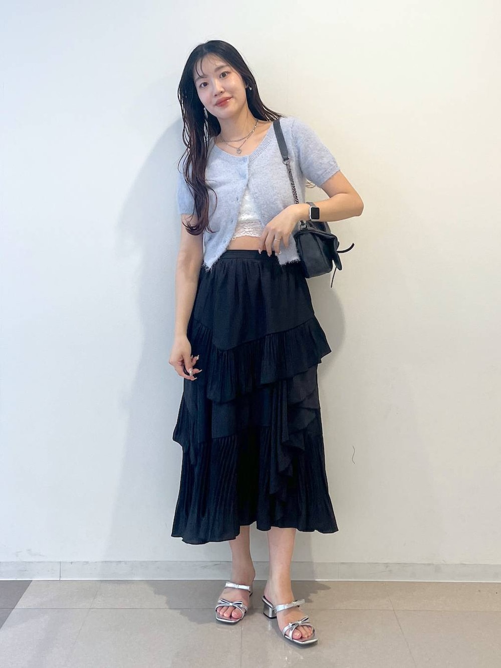 グレー系のショルダーバッグ、ブラック系のスカート、ホワイト系のキャミソールを着用したレディースの春コーディネートの2枚目の写真