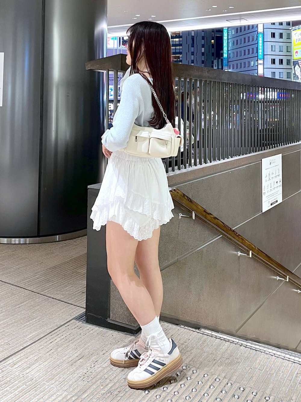 ホワイト系のキャミソール、ホワイト系のショルダーバッグ、ブルー系のカーディガン/ボレロを着用したレディースの春コーディネートの2枚目の写真