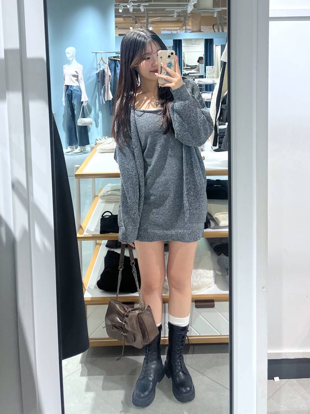 ブラウン系のショルダーバッグ、ブラック系のブーツ、ホワイト系のTシャツ/カットソーを着用したレディースの冬コーディネートの7枚目の写真