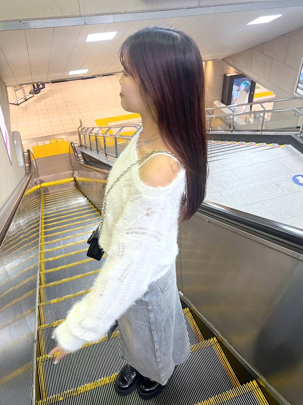 ブルー系のデニムスカート、ホワイト系のキャミソール、ブラック系のローファーを着用したレディースの秋コーディネートの3枚目の写真