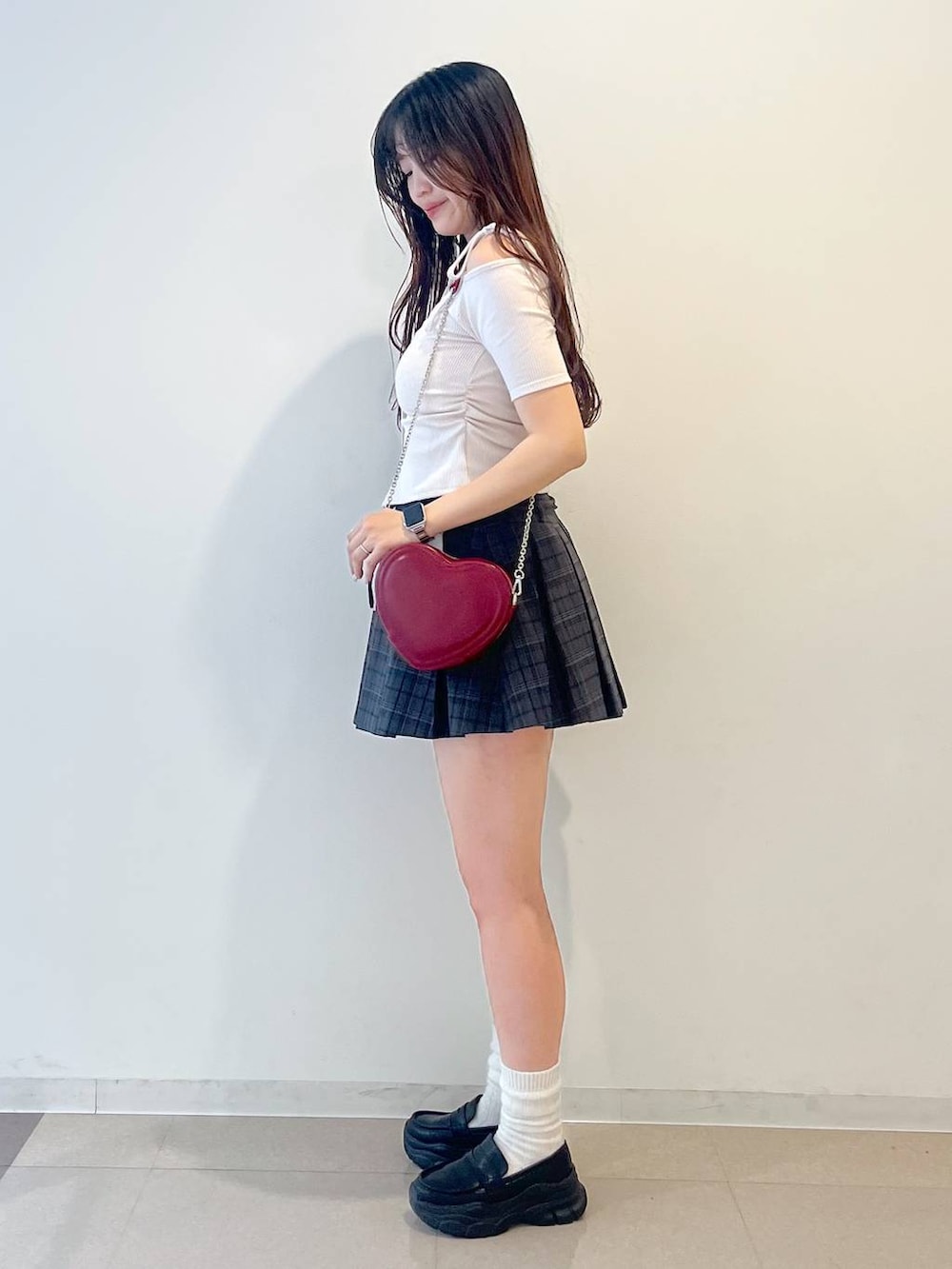 ブラック系のローファー、グレー系のスカート、レッド系のショルダーバッグを着用したレディースの春コーディネートの3枚目の写真