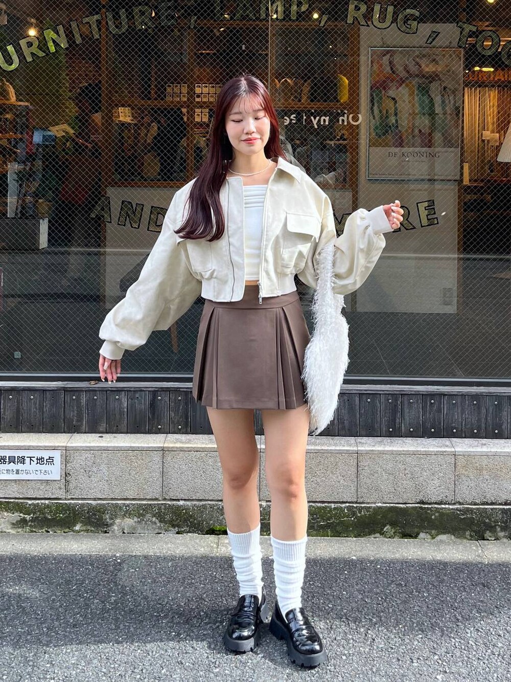 ブラウン系のスカート、ホワイト系のショルダーバッグ、ブラック系のローファーを着用したレディースの秋コーディネートの10枚目の写真