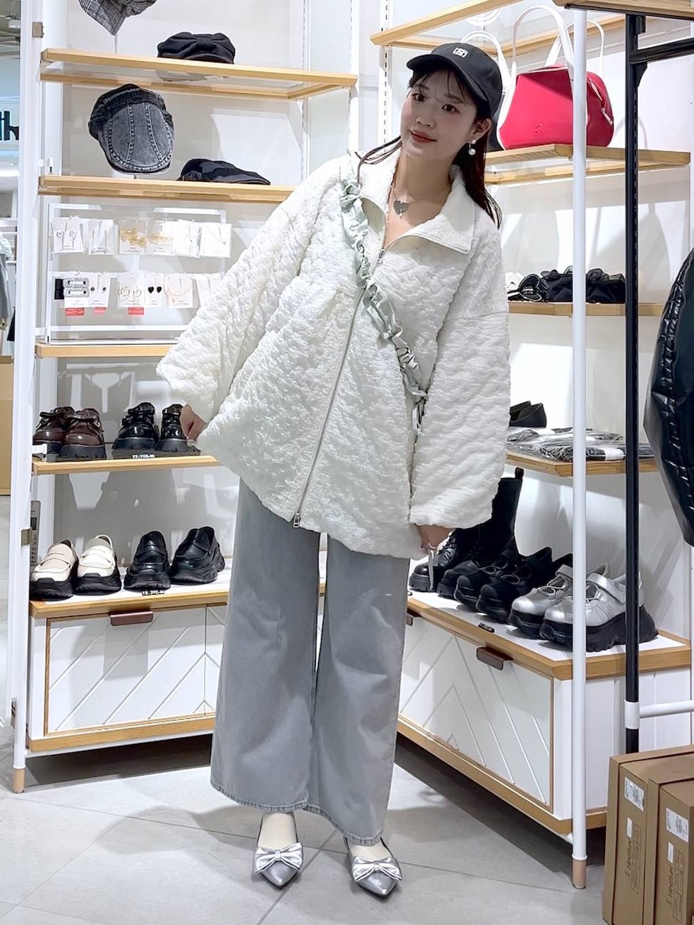 ブルー系のデニムパンツ、グリーン系のショルダーバッグ、シルバー系のパンプスを着用したレディースの春コーディネートの3枚目の写真