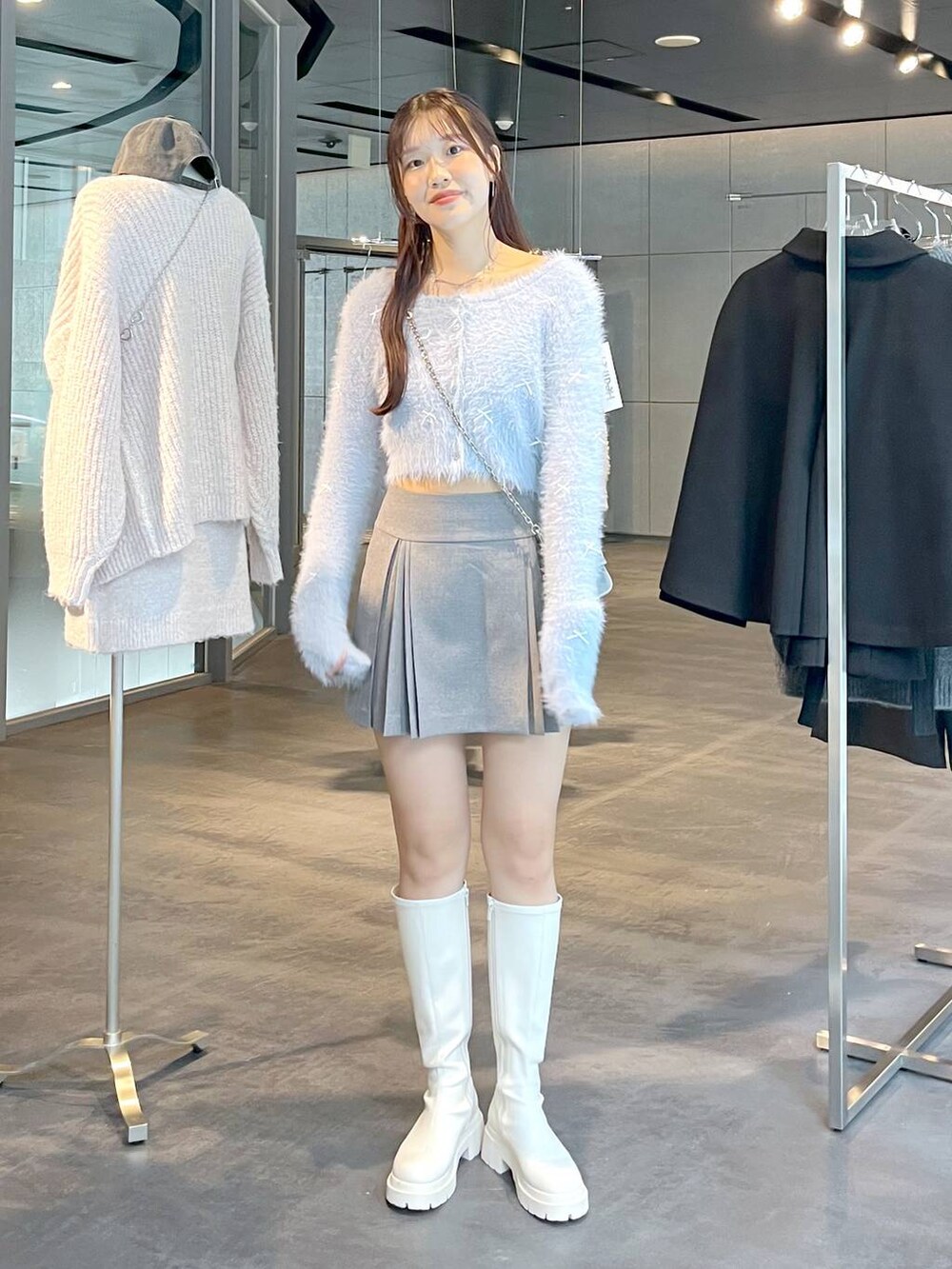 グレー系のスカート、ホワイト系のブーツ、ホワイト系のTシャツ/カットソーを着用したレディースの秋コーディネートの4枚目の写真