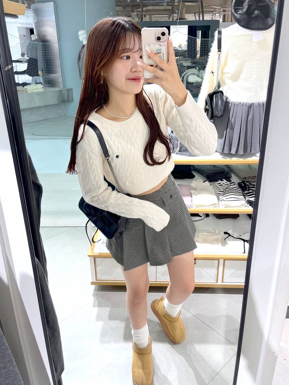 ホワイト系のニット/セーター、ブラック系のショルダーバッグ、ベージュ系のスカートを着用したレディースの秋コーディネートの2枚目の写真