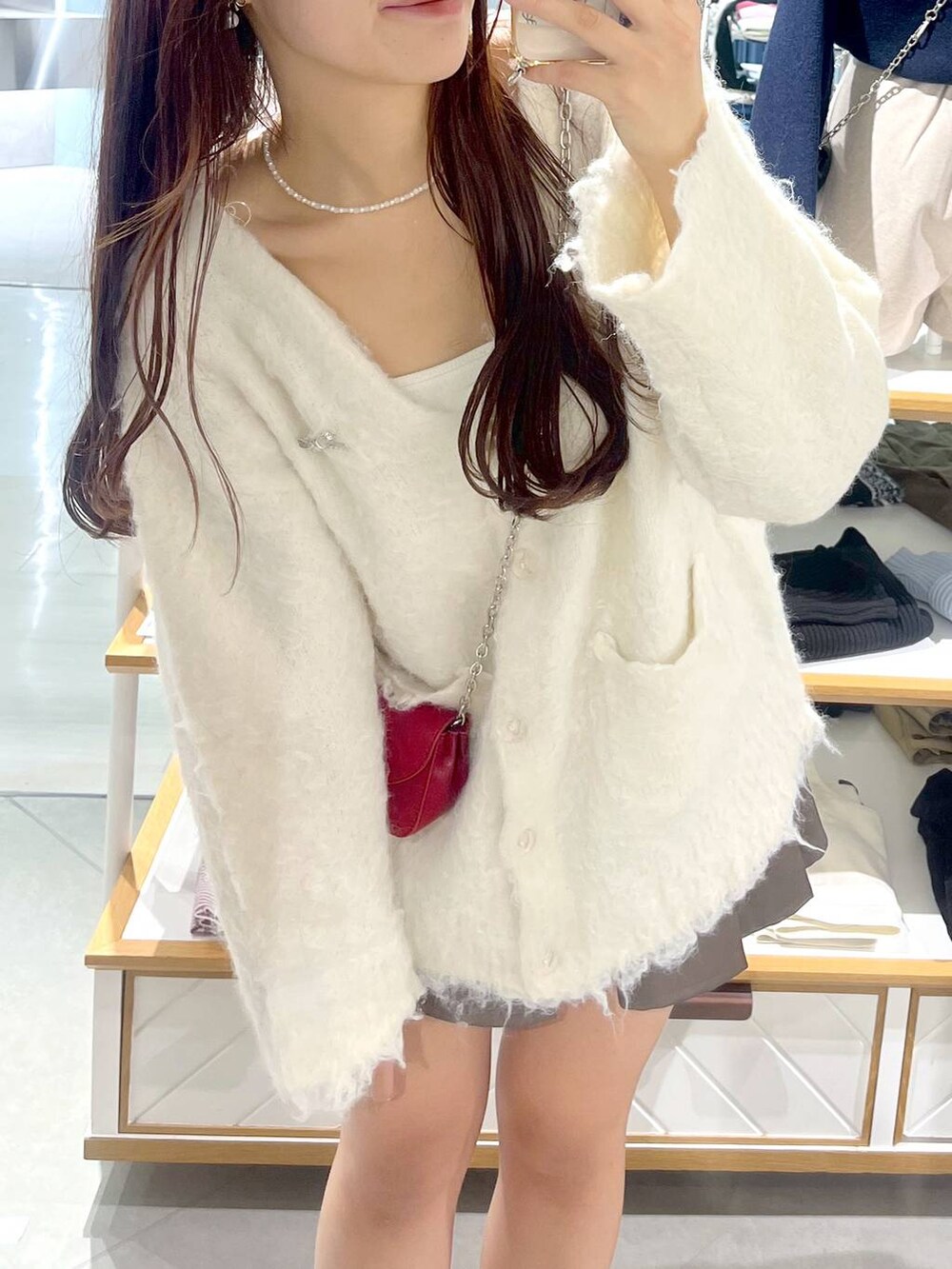 ブラウン系のスカート、ホワイト系のカーディガン/ボレロ、ベージュ系のブーツを着用したレディースの秋コーディネートの5枚目の写真